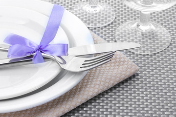 White empty plates, fork and knife tied with a ribbon and