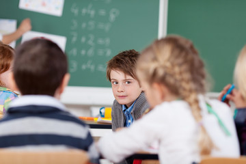 junge in der schulklasse schaut nach hinten