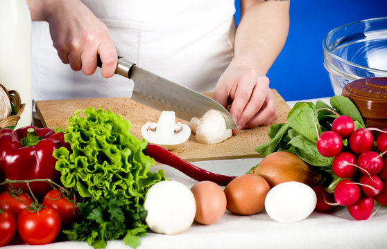 Female hands are cut by vegetables and food ingredients
