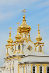 Fototapeta na wymiar White Cathedral with golden cupolas in Peterhof
