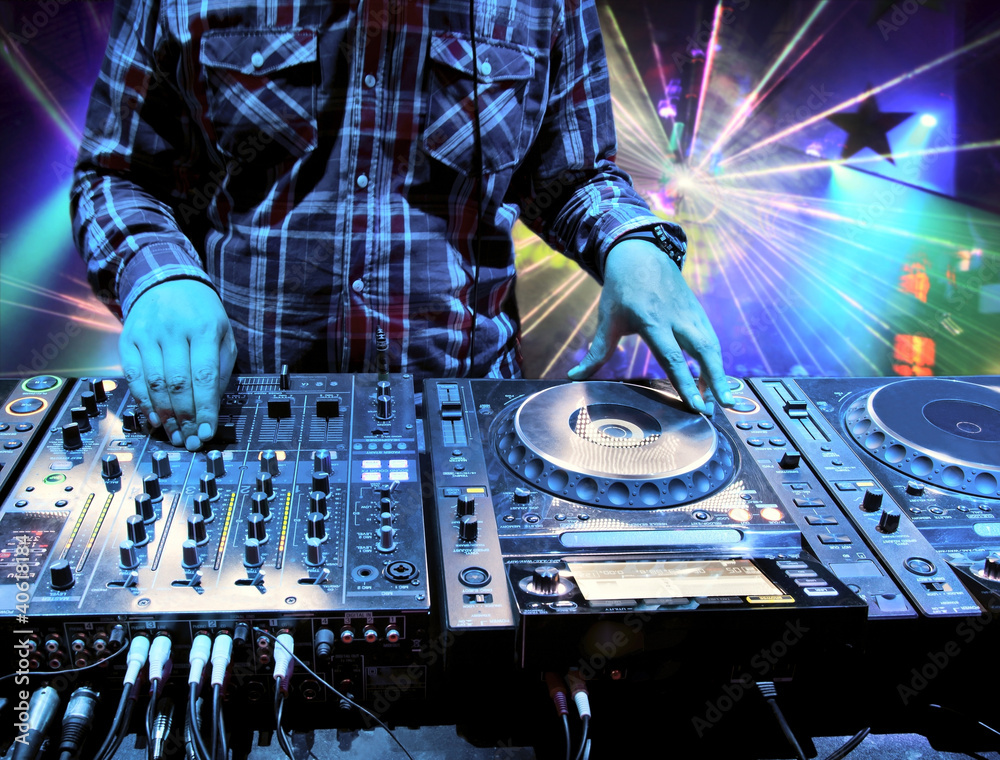 Wall mural Dj mixes the track in nightclub at party