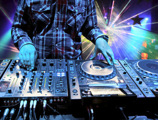 Dj mixes the track in nightclub at party