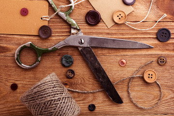 Old scissors and buttons on the wooden table