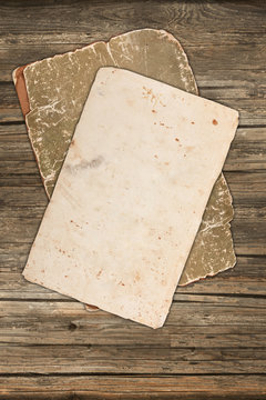 Grungy blank paper and old cardboard on a wooden background