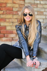 Young blond woman in a jacket and aviator sunglasses