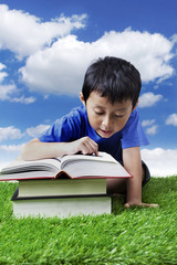 Boy reading books outdoor