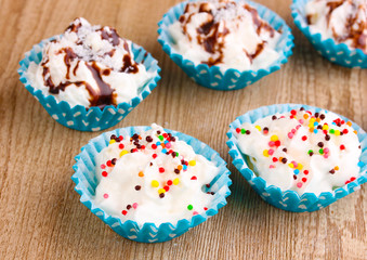 Creamy cupcakes on wooden background close-up