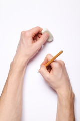 Image of human hands with pencil and eraser on white