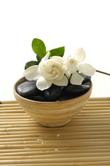 Gardenia flower and stones in wooden of on mat