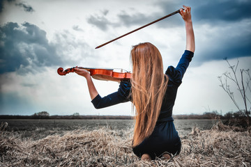 The red-haired girl with a violin outdoor © Andriy Petrenko
