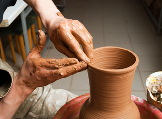 hands of a potter, creating an earthen jar on the circle
