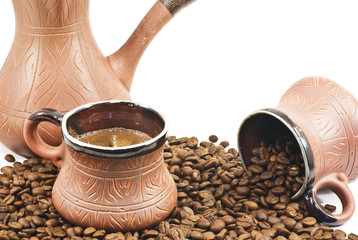 two brown ceramic coffee cup filled  and ceramic coffee maker w