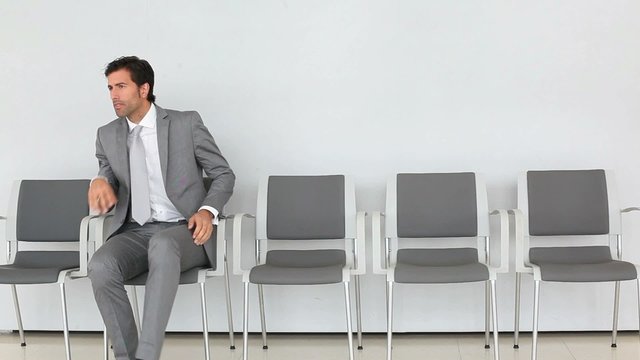Businessman sitting in waiting room chair