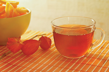 Tea and fruit jelly with physalis on a bamboo table cloth