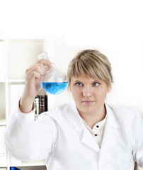 female chemist mixing liquids in test tubes