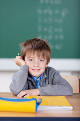 junge in der schule stützt kopf auf