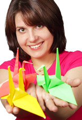 Portrait of a beautiful smiling brunette holding paper crane