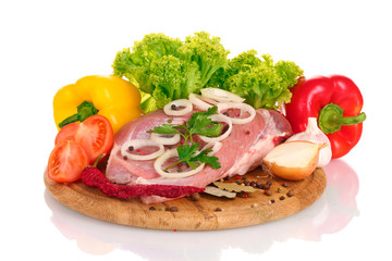 Raw meat and vegetables on a wooden board isolated on whitе