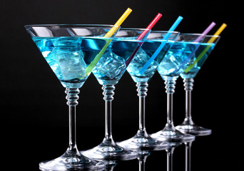 Blue cocktail in martini glasses isolated on black