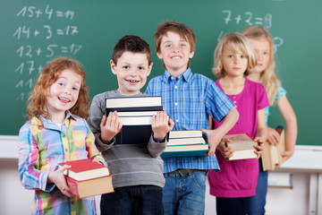 schulkinder mit büchern vor der tafel