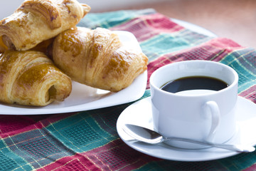 Breakfast with a cup of black coffee and croissants, Shallow DOF