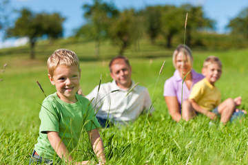 Familie mit Kindern auf einer Wiese