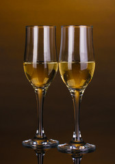 Glasses of champagne on brown background