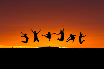 Fototapeta na wymiar silhouette of friends jumping in sunset