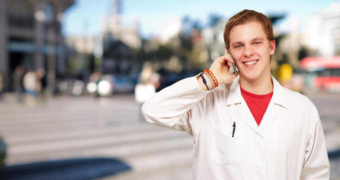 portrait of young academic talking on mobile at crowded street