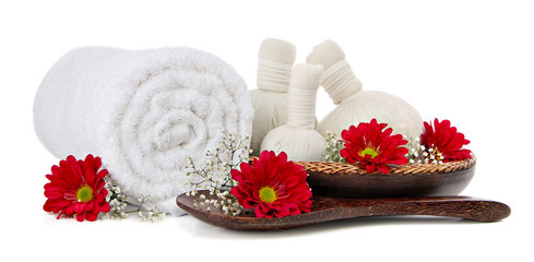 Spa massage setting with rolled towel and flowers