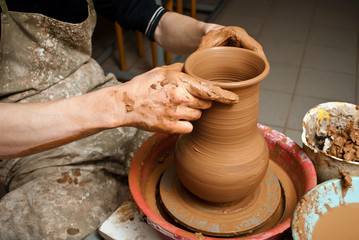 hands of a potter, creating an earthen jar on the circle