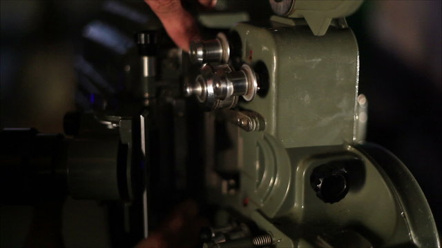 mechanic puts film in film projector