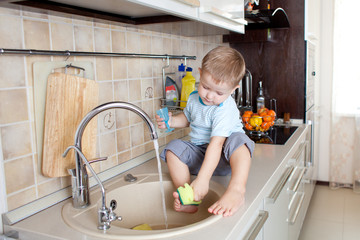 funny little boy sitting on kitchen table