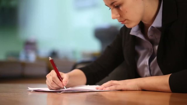 Close-up of young woman with pen and documents