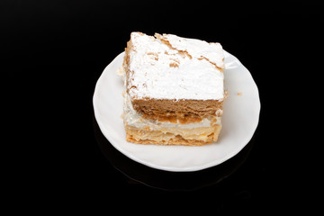 sweet  cake with cream isolated on black