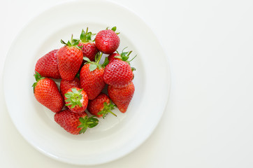 fresh ripe strawberries on a white plate