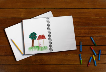 drawing book and creyon on wood background