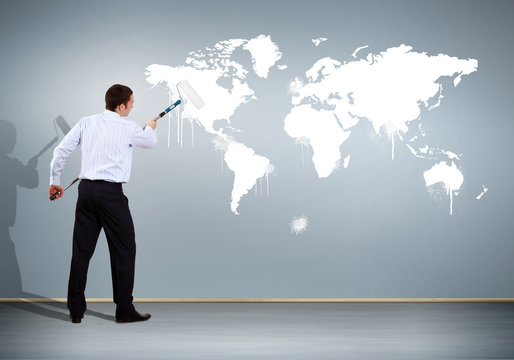 Businessman with paint brush and world map