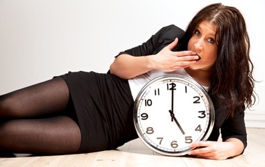 A Tired Woman Holding a Clock