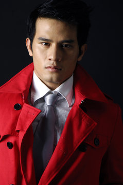 Young Handsome Man In Red Coat On Black Background