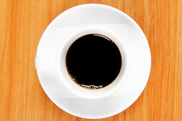 View top of black coffee cup on wood