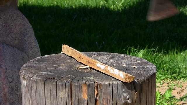Wood chopping with ax on trunk, outdoors