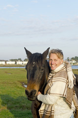 A blond man with his brown horse.