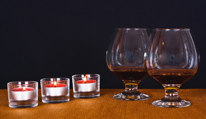 Two glasses of brandy and lit candles