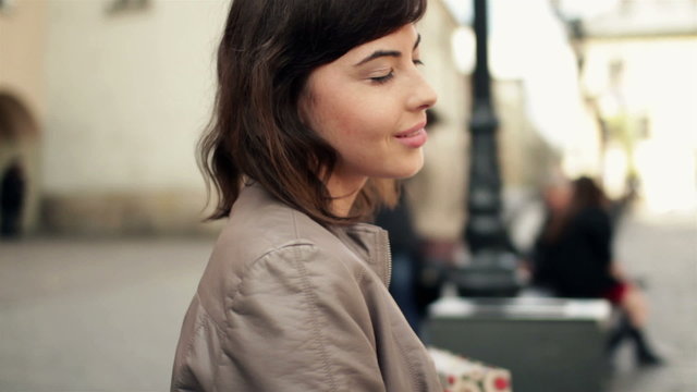 Attractive smiling happy woman in the city, steadicam shot