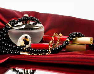 Perfume bottle, red lipstick and pearls beads