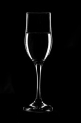 Transparent wine glass filled with water on black