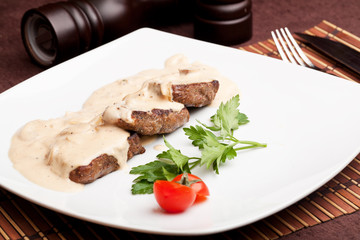 Roasted meat under white sauce