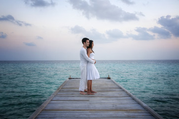 Perfekt happy love couple in white clothes on a jetty (Maldives)