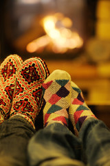 Young romantic couple relaxing in front of fireplace at home